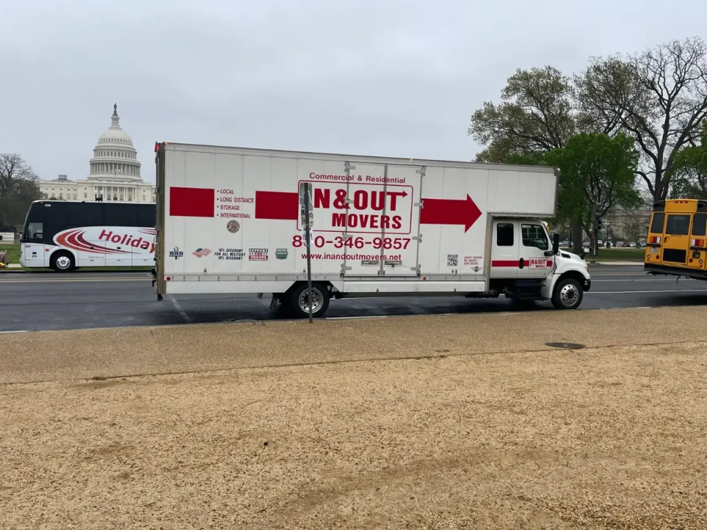 In & Out Movers truck parked near the U.S. Capitol, advertising local and long-distance in town movers services.