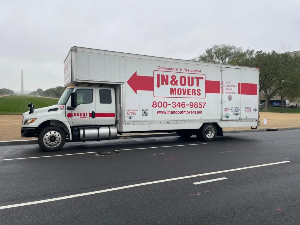 In & Out Movers truck parked near the Washington Monument, promoting in town movers with contact 800-346-9857.