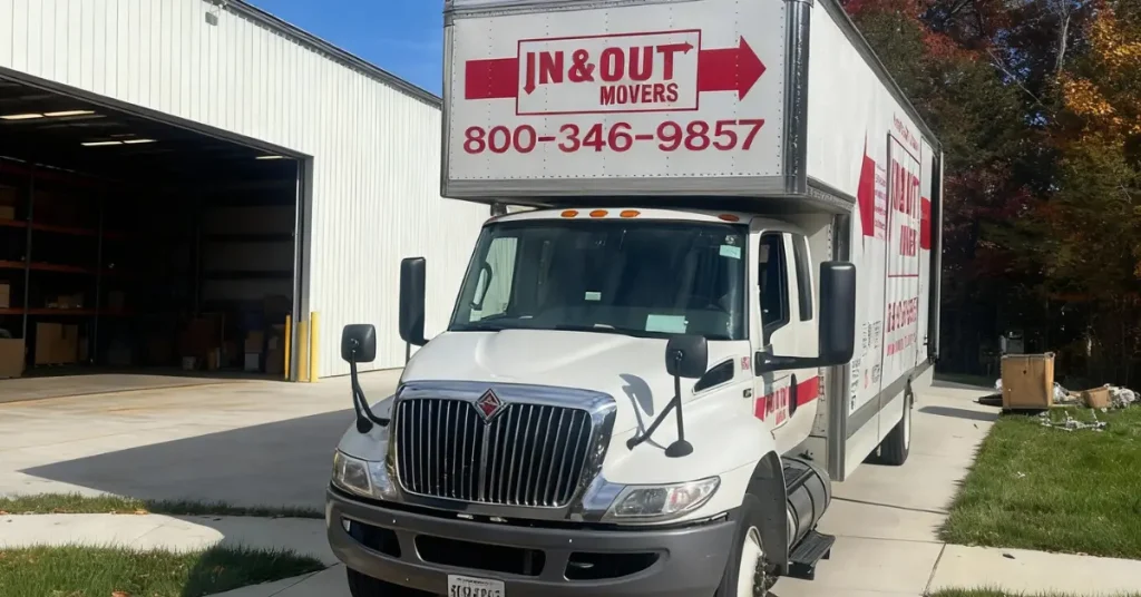In & Out Movers truck parked outside a warehouse during a warehouse relocation service.