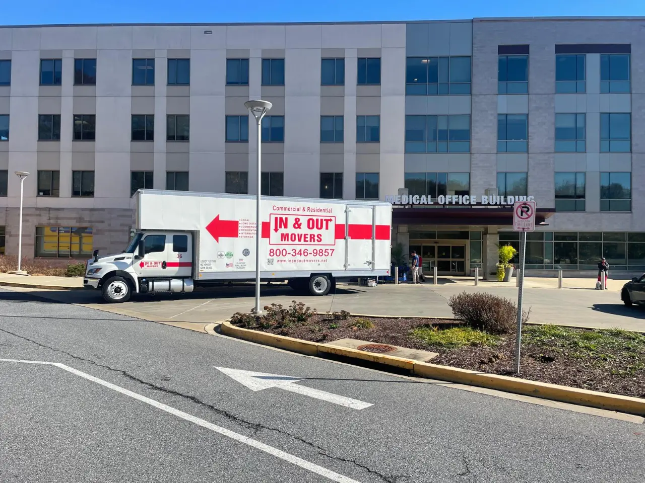 In & Out Movers white glove movers truck parked on a residential street during a home move.